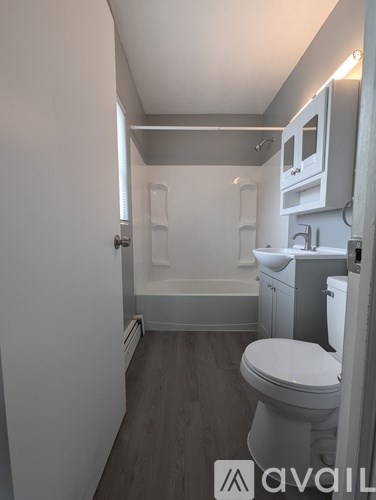 A small bathroom with a toilet, sink and bathtub.