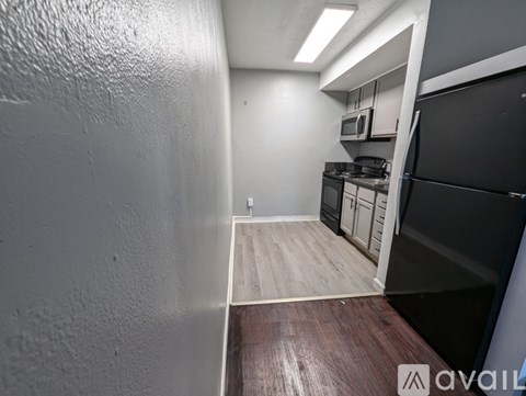 A kitchen area with a black fridge, microwave, and oven.