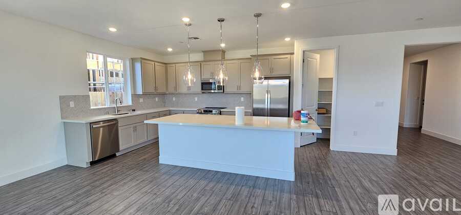 A modern kitchen with a center island and pendant lights.