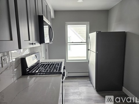 A kitchen with a stove top oven and a refrigerator.