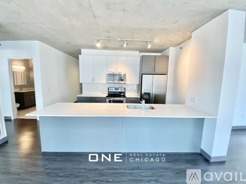A modern kitchen with white cabinets and a large island in the middle.