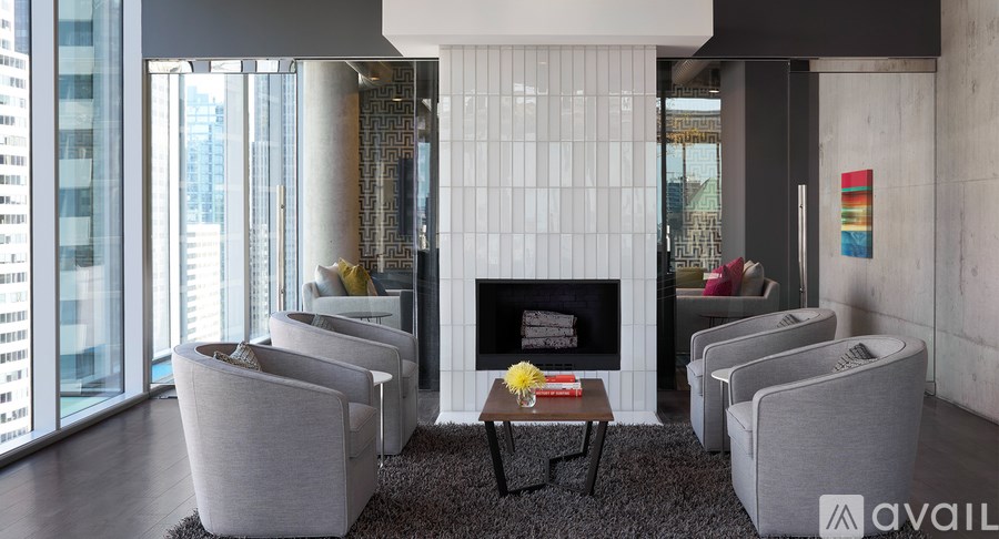 A living room with a fireplace and grey couches.