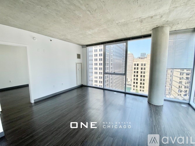 A spacious room with a view of the cityscape through large windows.