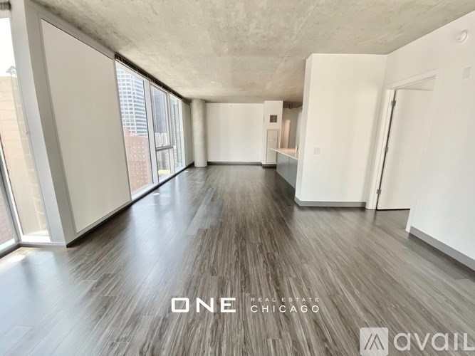 A spacious room with wooden flooring and large windows is available for rent in Chicago.