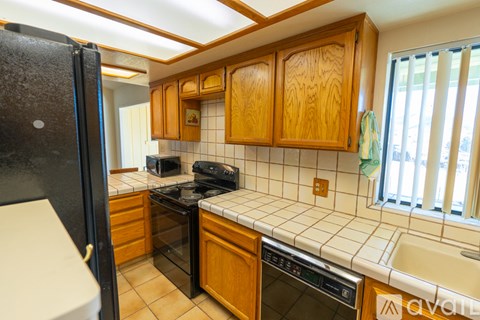 A kitchen with wooden cabinets and black appliances.