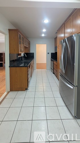 A kitchen with a refrigerator on the right and a counter on the left.
