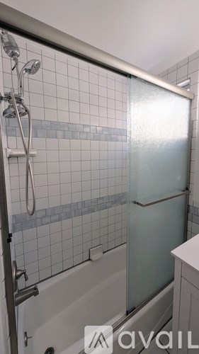 A shower area with a glass door and a shower head.