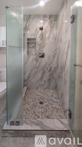 A marble bathroom with a glass shower door.