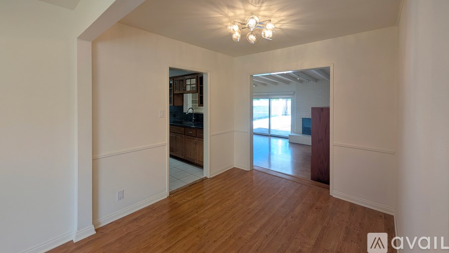 A room with wooden floors and a chandelier.