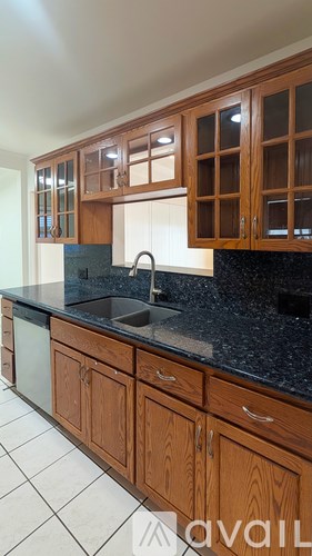 A kitchen with wooden cabinets and a black countertop.