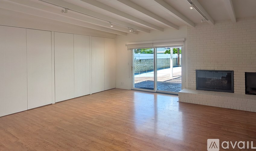 A spacious living room with a fireplace and sliding glass doors.