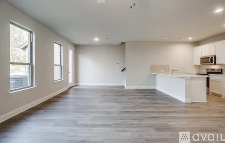 A spacious, empty room with a kitchen area to the right.