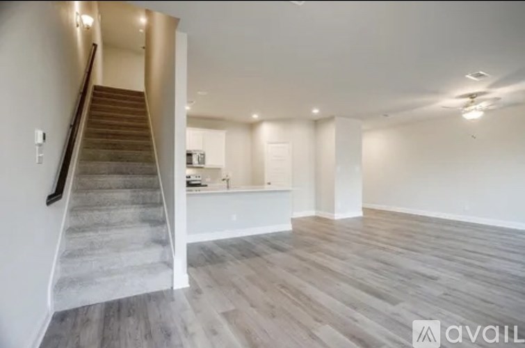 A spacious room with a staircase leading to the upper floor.