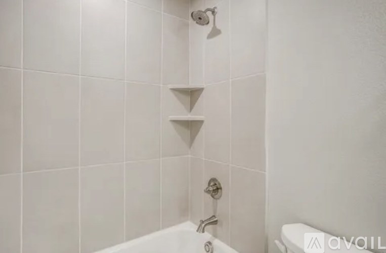 A white bathroom with a shower head and a bathtub.