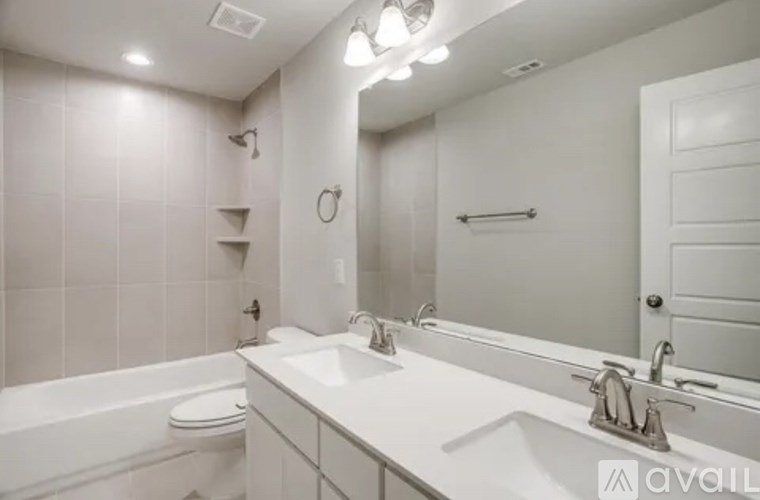 A white bathroom with a toilet, sink, and bathtub.