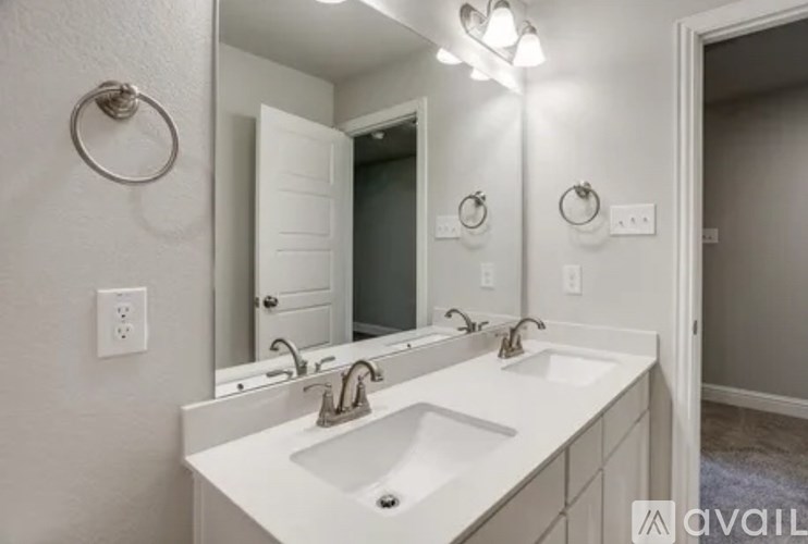 A bathroom with a white sink and mirror.