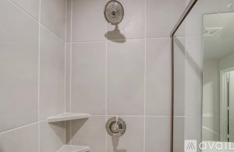 A shower head mounted on a wall in a bathroom.
