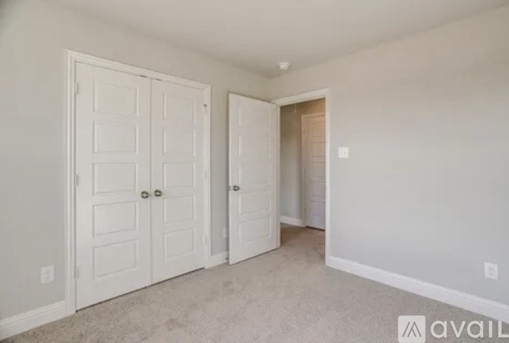 A room with two doors and a carpeted floor.