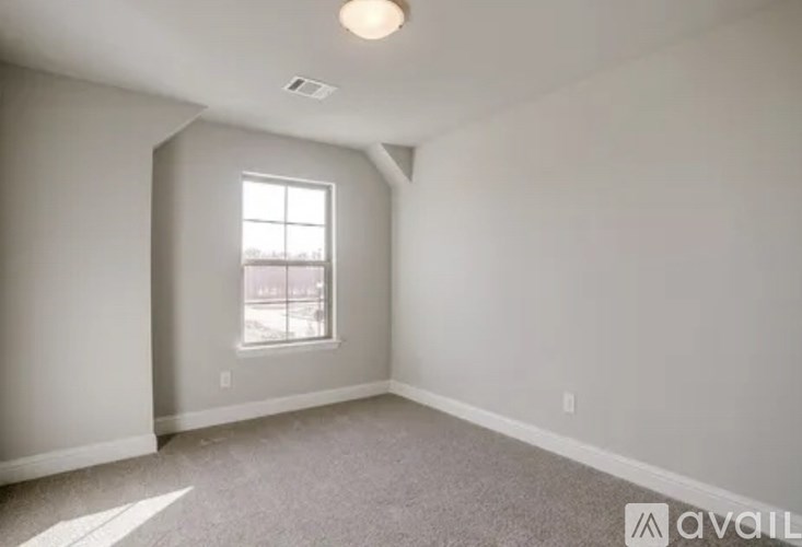 A room with a window and a car parked outside.