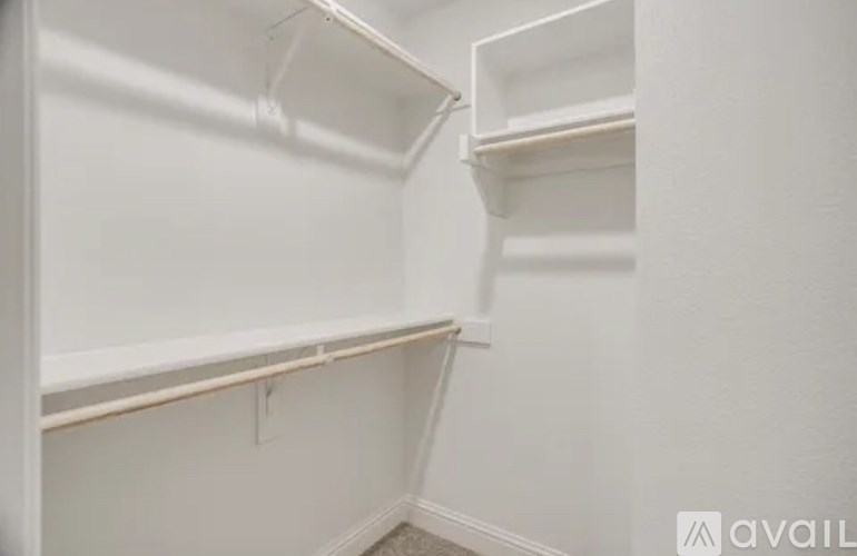 A white closet with shelves and a hanging rod.