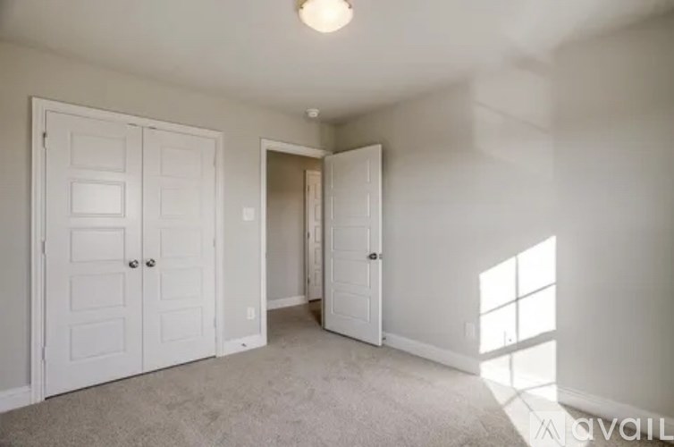 A room with two doors and a carpeted floor.