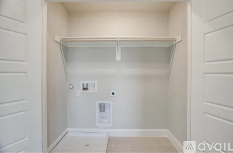 A white closet with a shelf and a white door.