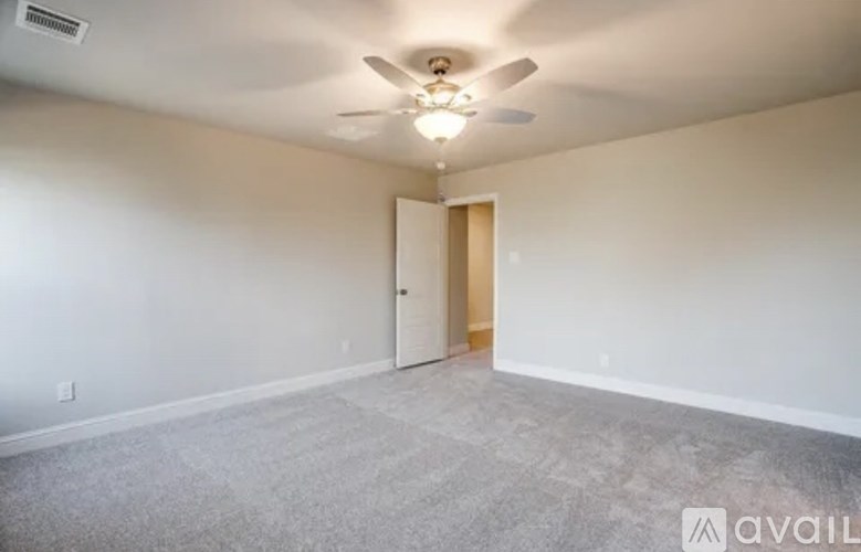 A room with a ceiling fan and carpeted floor.