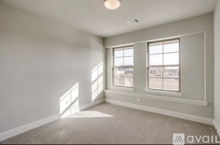 A room with a carpeted floor and three windows.