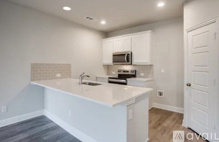 A kitchen with white cabinets and a white countertop.