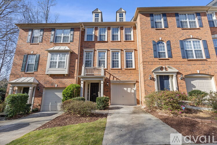 A large brick apartment building with a driveway in front.