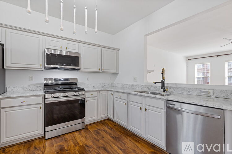 A kitchen with white cabinets and a stainless steel dishwasher.