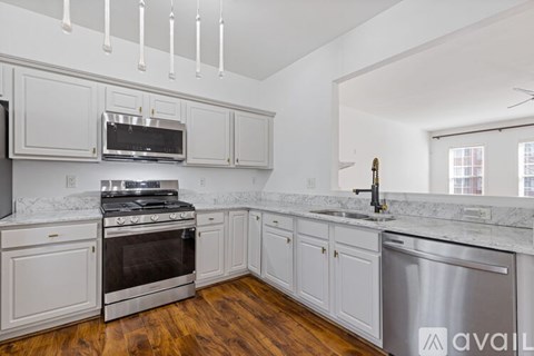 A kitchen with white cabinets and a stainless steel dishwasher.