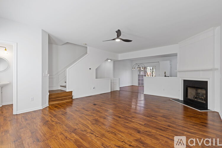 A spacious living room with a fireplace and hardwood floors.