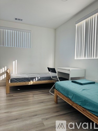 A bedroom with a bed, desk, and chair.