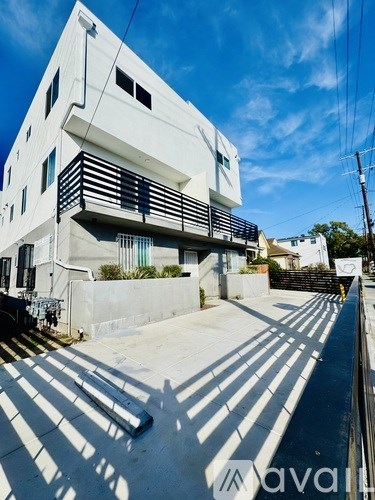 A white modern building with a clear blue sky in the background.