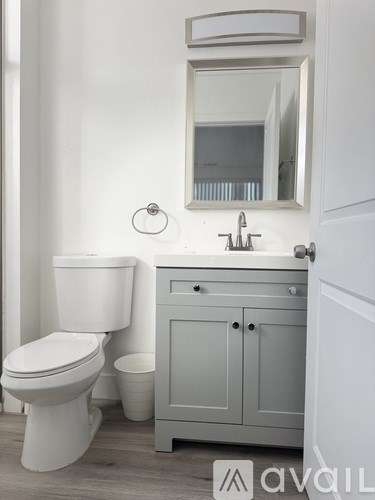 A white toilet sits next to a sink in a bathroom.
