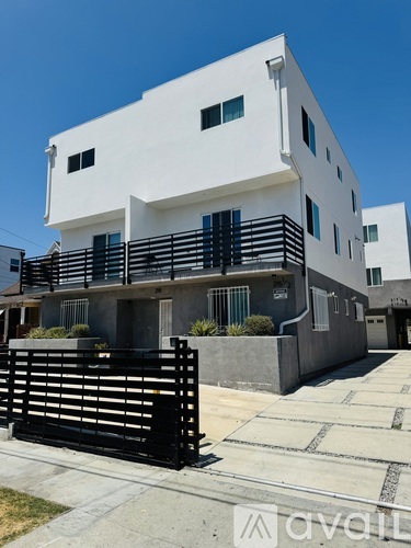 A white modern building with a clear blue sky in the background.