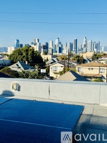 A rooftop with a solar panel and a city skyline in the distance.