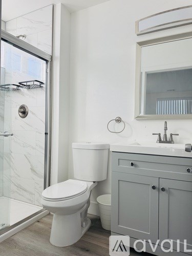 A white toilet sits next to a sink in a modern bathroom.