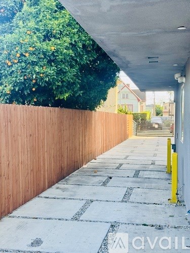 A long concrete walkway with a yellow post on the right side.