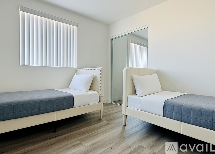 A living room with a grey sofa and a white desk.