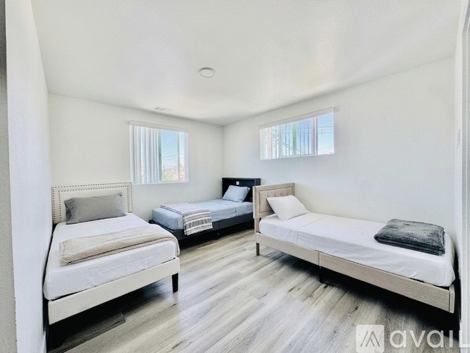 A bedroom with two beds and a window.
