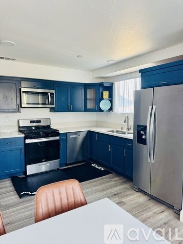 A kitchen with a refrigerator, stove, and sink.