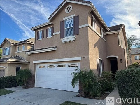 A two-story house with a garage and a driveway.