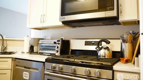 A modern kitchen with a stove top oven and microwave above it.