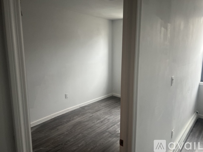 A room with a wooden floor and white walls.