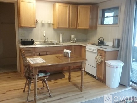 A kitchen with wooden cabinets and a white stove top oven.
