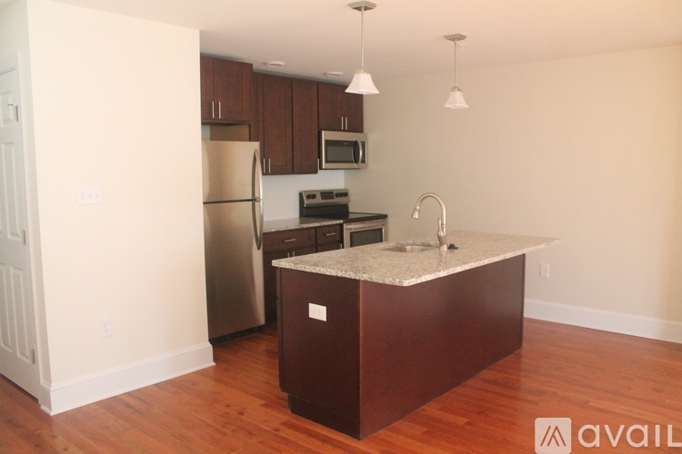 A kitchen with a refrigerator, microwave, oven, and sink.