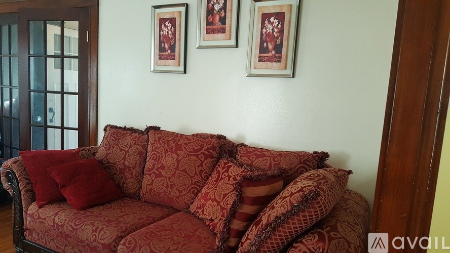 A red sofa with pillows in a room.