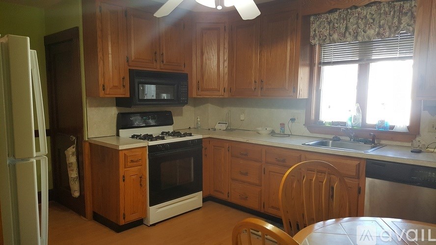 A kitchen with wooden cabinets and a white refrigerator.